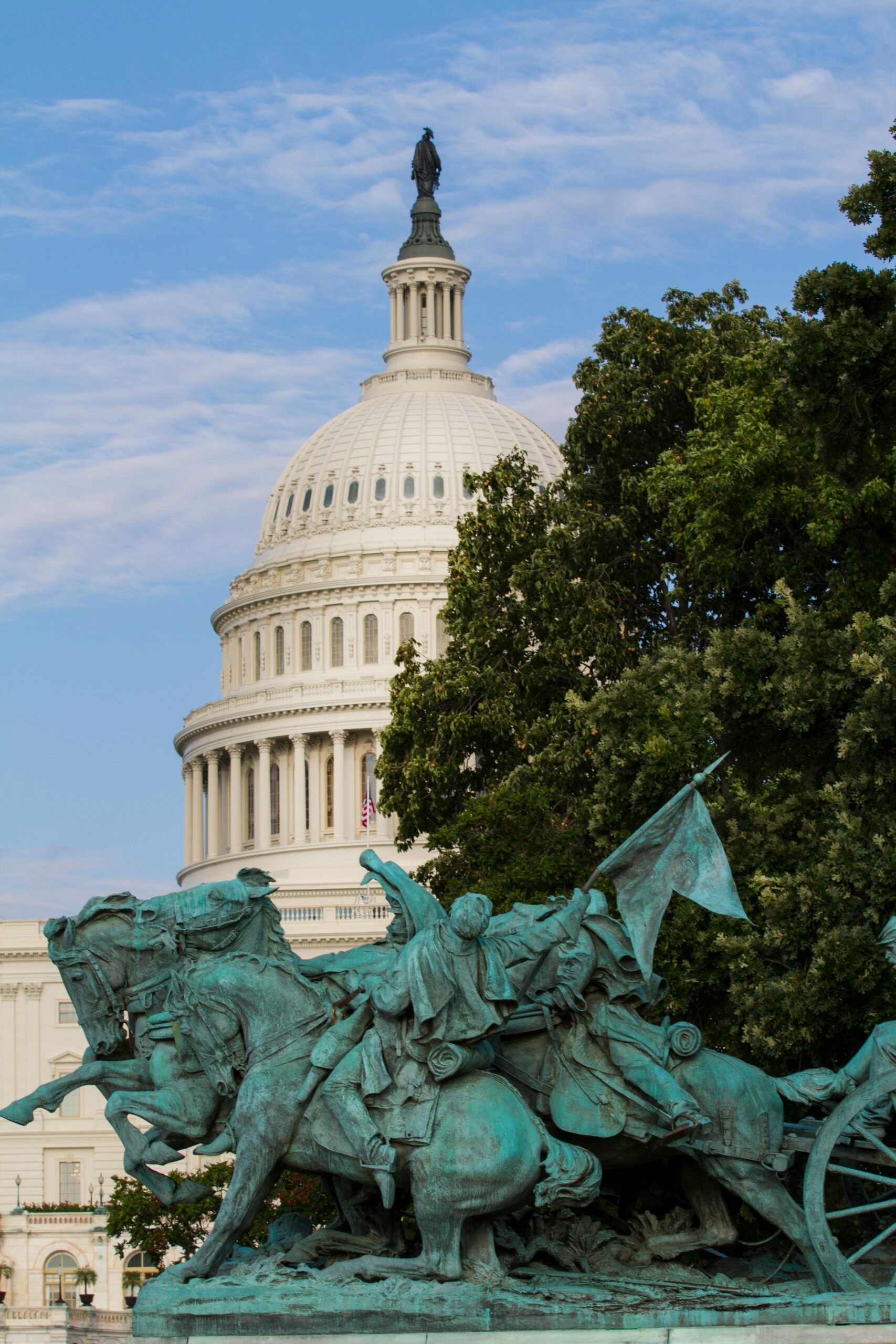 blue green statue in front of the washington capitol building