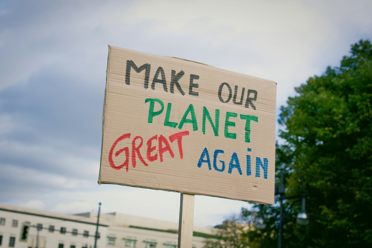 Picture of cardboard sign that says "Make our planet great again" in multiple colors